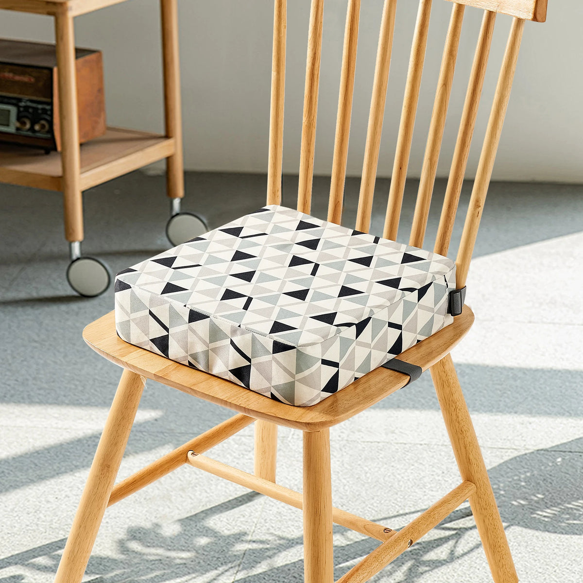 Coussin rehausseur à sangles triangle installé sur une chaise