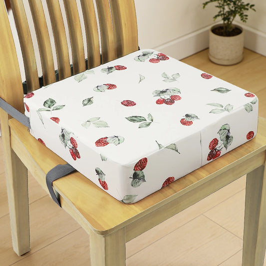 Coussin rehausseur enfant en polyester sur une chaise en bois